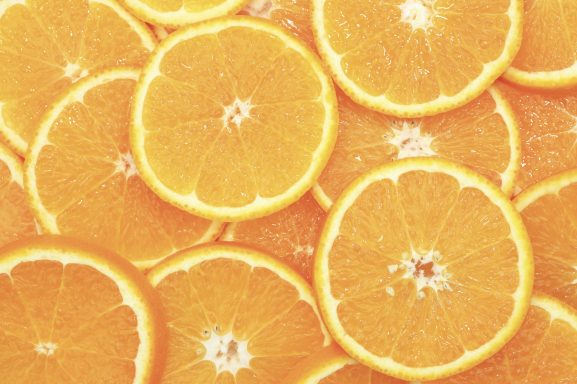 Scheiben von frischen Orangen, gleichmäßig übereinandergelegt und leuchtend orange.